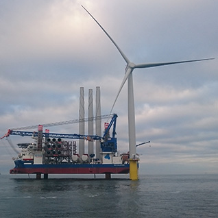 The installation vessel Sea Challenger behind the very first turbine installed at the Dudgeon field.